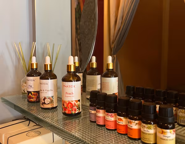Bottles of massage oil and essential oils on a glass shelf